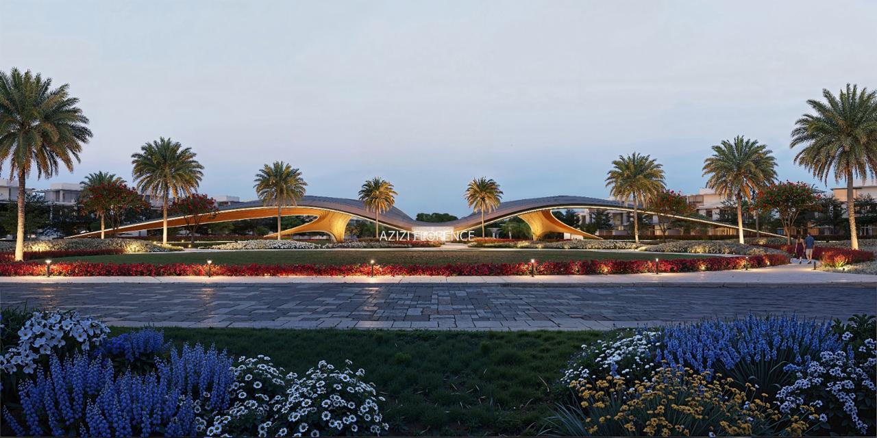 Azizi Florence Sharjah — the community gateway lit at dusk